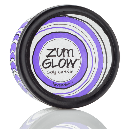 Top view 7 oz Lavender Candle in a black tin with purple and white label that has circular designs.